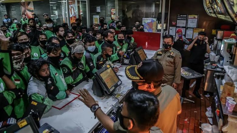 Delivery drivers attempt to collect “BTS Meal” orders in Bogor, Indonesia