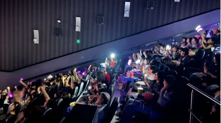 Fans watching HYBE CINE FEST in LATAM screenings at a Latin American theater