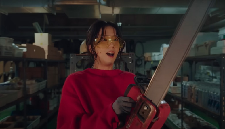 Jisoo carrying chainsaw in “Newtopia.” | YouTube