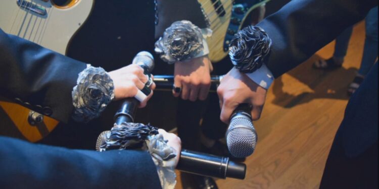 The Rose members pre-show ritual with silver roses fist bumping their microphones before their concert Credit: Photo by Jaehyeong Lee, Courtesy of THE ROSE: COME BACK TO ME